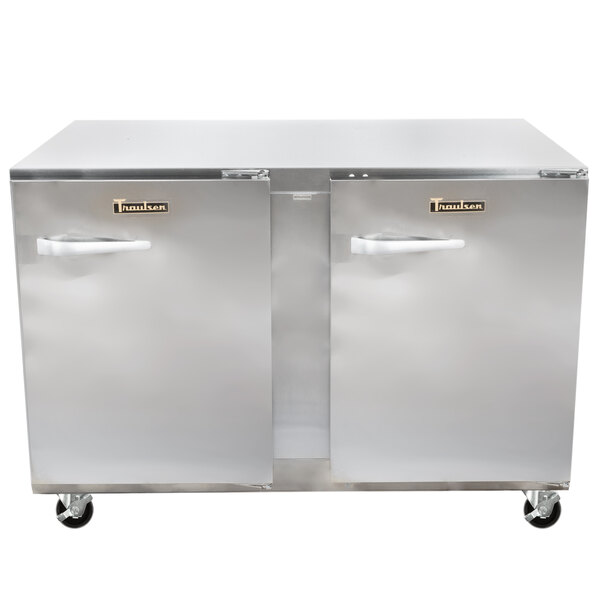 A close-up of a silver Traulsen undercounter refrigerator with two doors.
