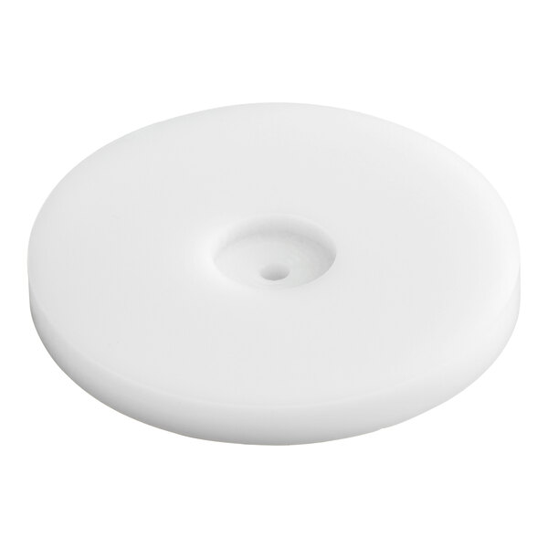 A round, white, flat disc with a small central hole and a slightly recessed center.