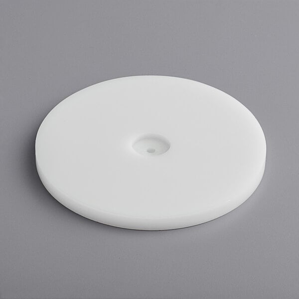 A white circular plastic disc with a hole in it.