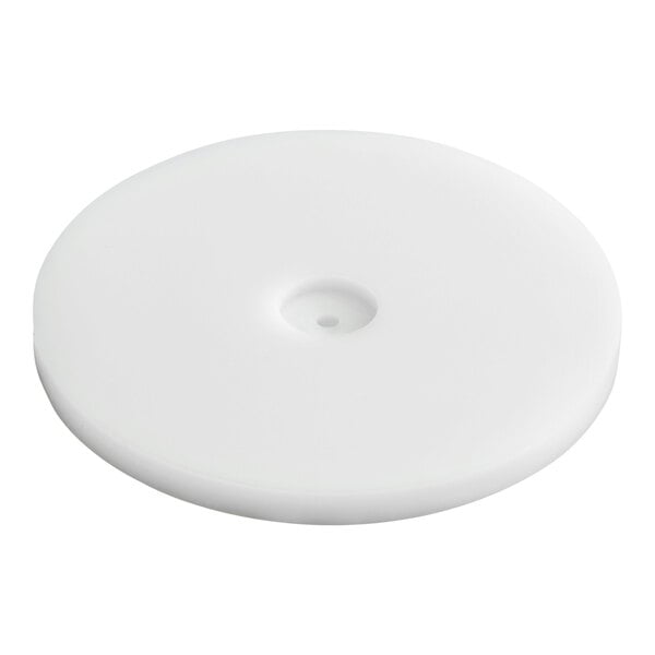 A round, flat, white plastic disc with a small central indentation and hole.