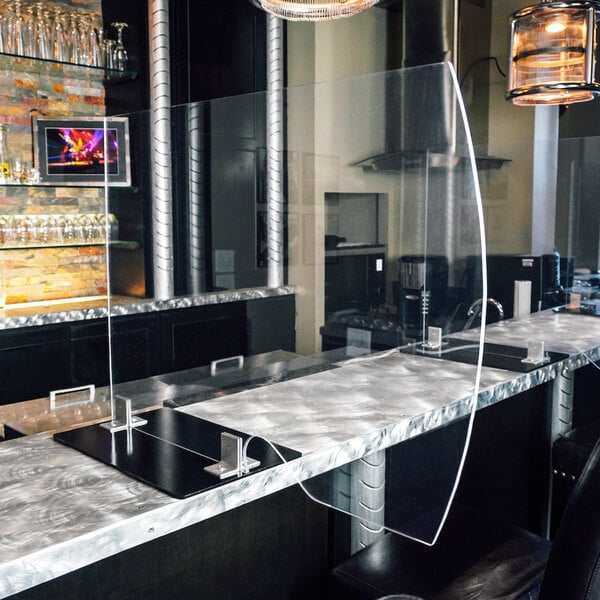 A Goff's clear plexiglass safety partition with steel rods on a black counter.