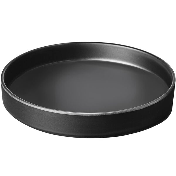 A black round melamine plate with a raised black rim.