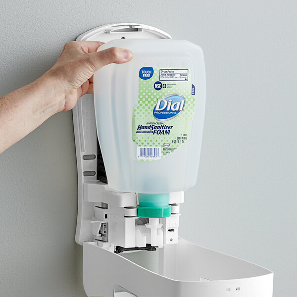 A hand holding a Dial hand sanitizer refill.