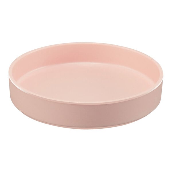 A round, blush-colored melamine plate with a raised rim.