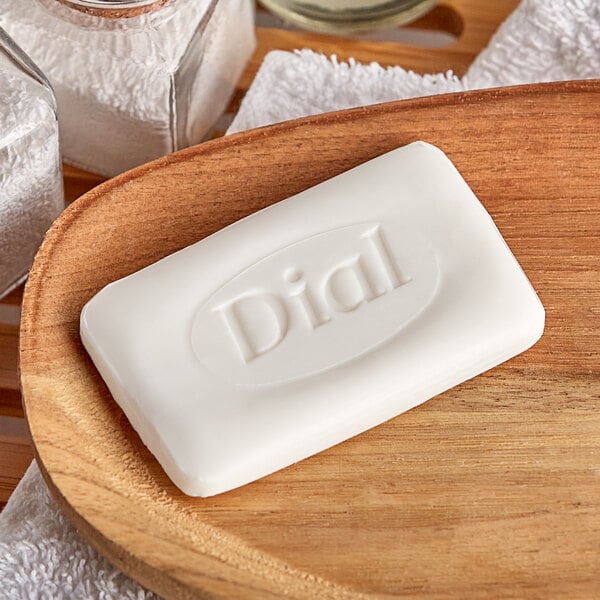 A white bar of Dial soap on a wooden surface.