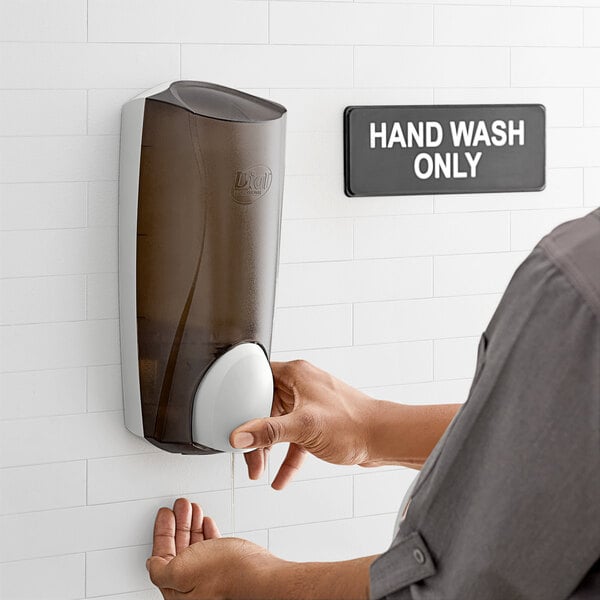 A person using a Dial smoke manual hand soap dispenser.