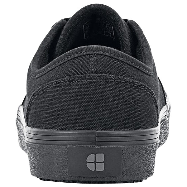 A black Shoes For Crews Merlin non-slip shoe with a logo on the side.