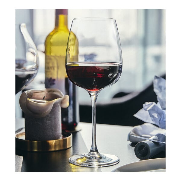 A close-up of a Chef & Sommelier Bordeaux wine glass with red wine in it.