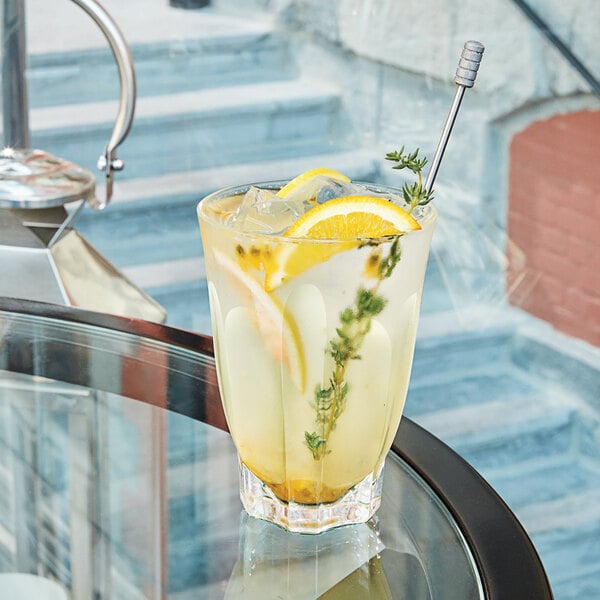 A Arcoroc highball glass of lemonade with a lemon slice and a sprig of rosemary.