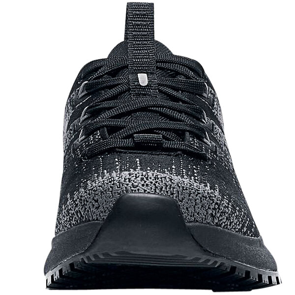 A black Shoes For Crews athletic shoe with a white sole.