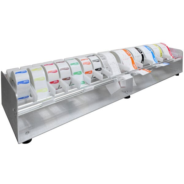 A Heat Seal PS-20 aluminum label dispenser holding rolls of labels on a metal stand.