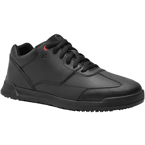 A black Shoes For Crews women's athletic shoe with laces.