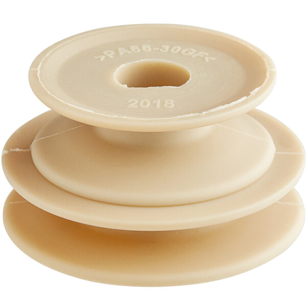 A close-up of a beige plastic circular pulley with a hole in the center.
