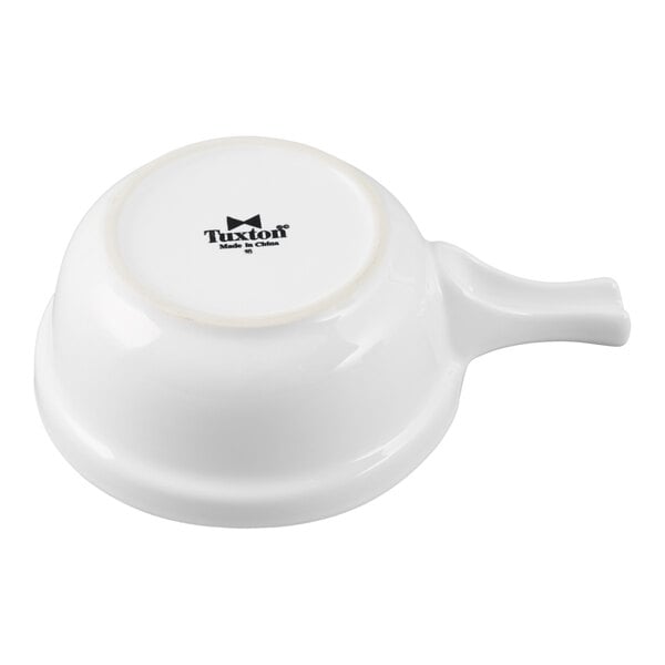 A white china French casserole bowl with a handle, shown upside down.