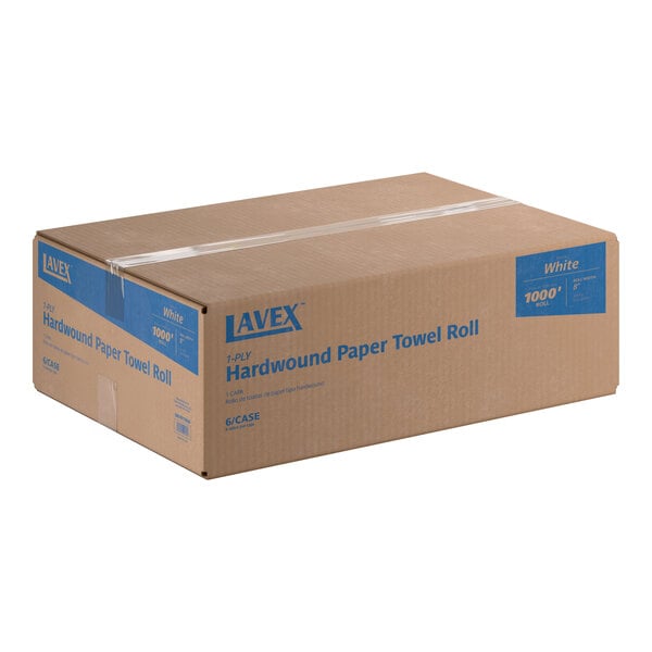 A large brown cardboard box labeled 'Lavex 1-Ply Hardwound Paper Towel Roll' with blue text and sealed with clear tape.