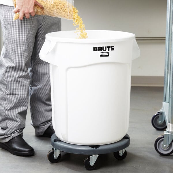 A man pouring corn into a Rubbermaid white round container.