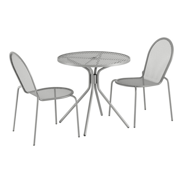 A Lancaster Table & Seating round outdoor table and 2 chairs with modern legs on an outdoor patio.