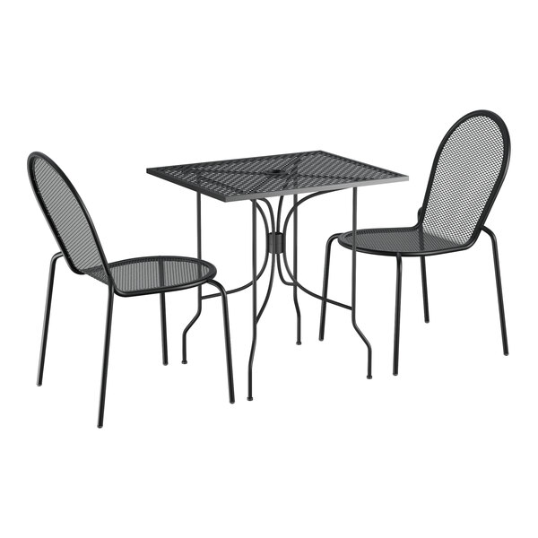 A Lancaster Table & Seating Harbor black metal table with ornate legs and two side chairs.