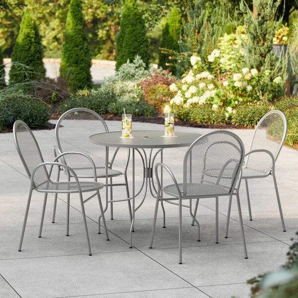 A Lancaster Table & Seating outdoor patio table with four arm chairs.