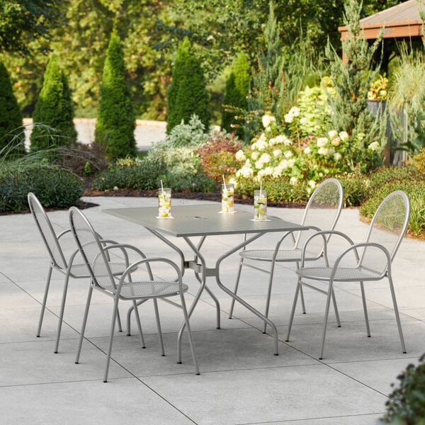 A Lancaster Table & Seating outdoor patio table with chairs on a patio.