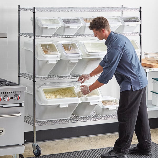 A man putting food into white Baker's Lane containers on a shelf.