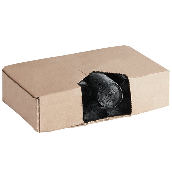 A cardboard box with rolls of black Lavex Hercules trash bags inside.