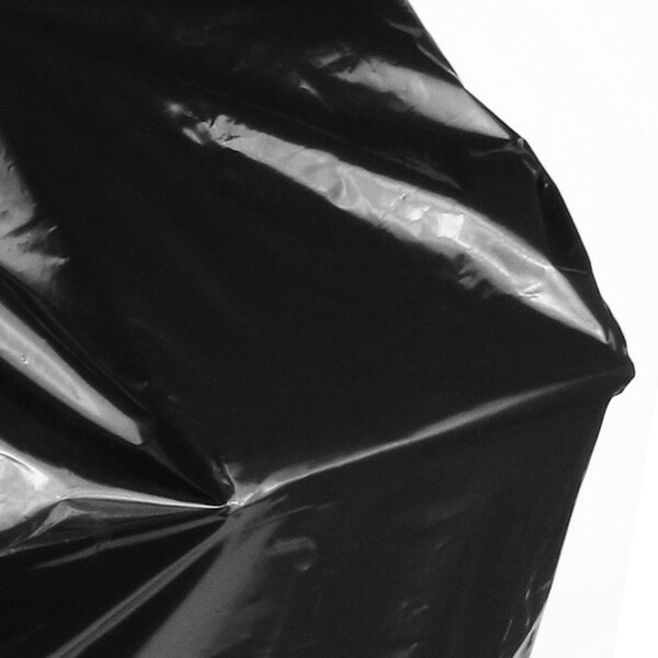A close-up of a black plastic bag with a crease.