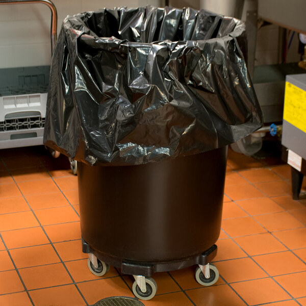 A black Lavex Hercules trash can on wheels with a black bag over it.