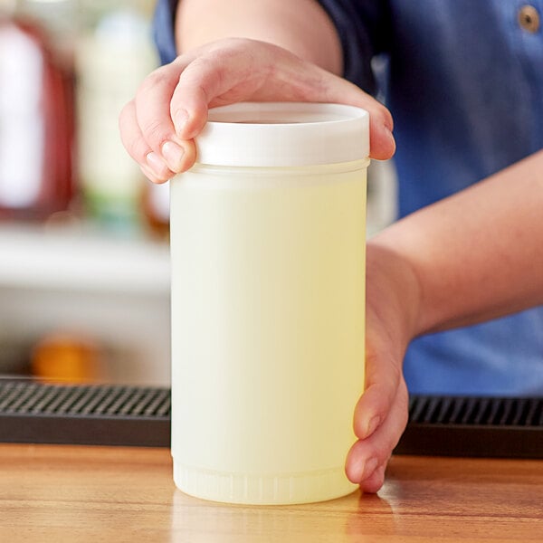 a person holding a container of liquid