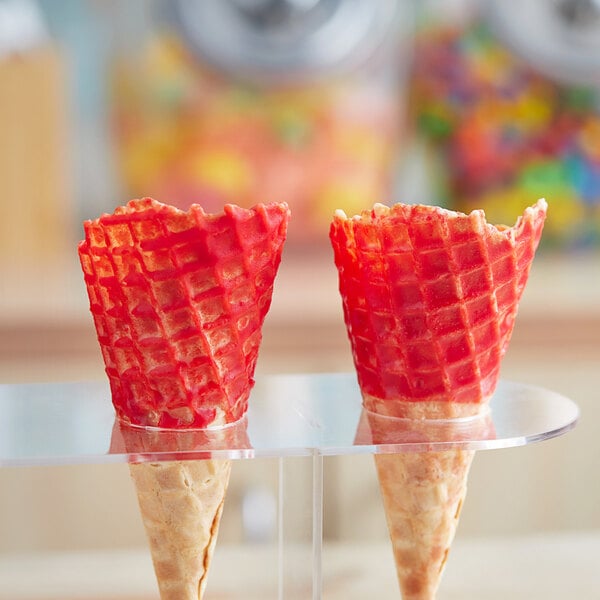 Two J. Hungerford Smith cherry cone shells on a clear stand.