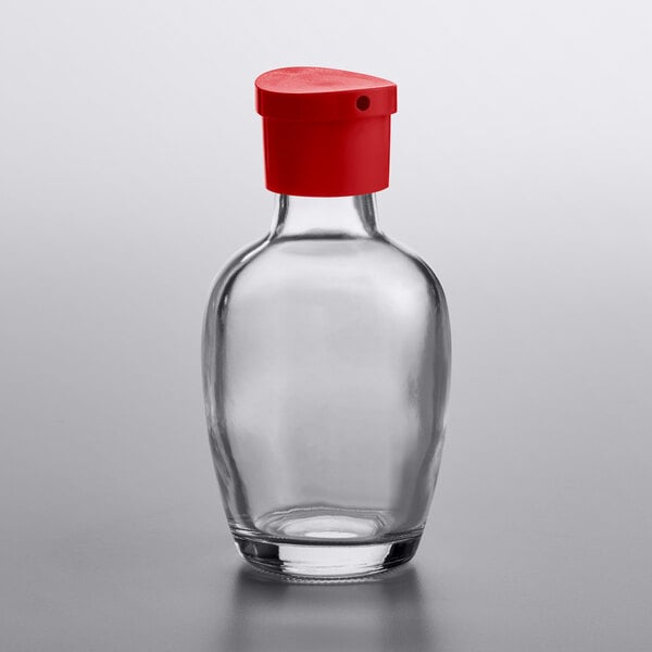 A clear glass Town Round soy sauce bottle with a red lid.