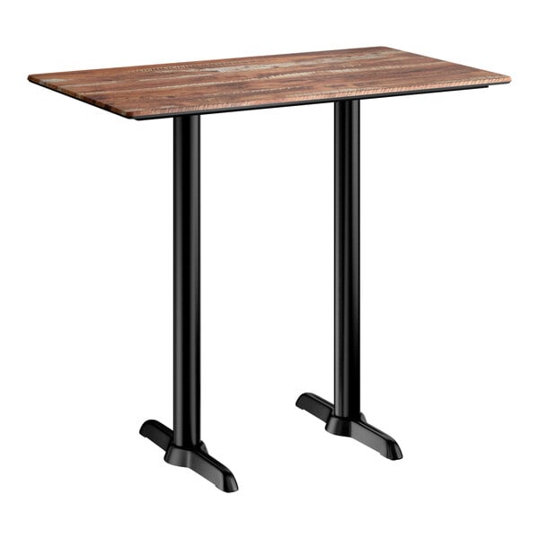 A rectangular bar height table with a textured Yukon oak finish top and two black metal end base plates.