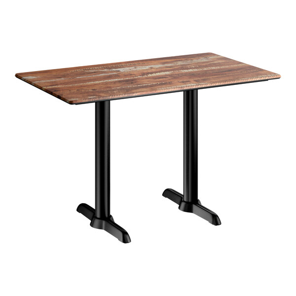 A rectangular standard height table with a textured oak finish top and two black metal base plates.