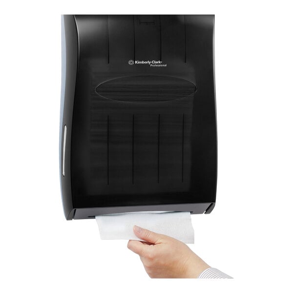 A hand using a white Scott multi-fold paper towel.