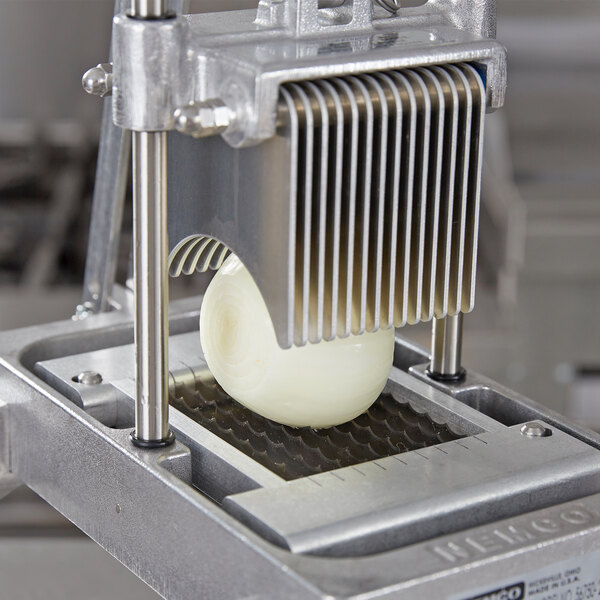 A Nemco 3/16" blade assembly cutting a white onion.