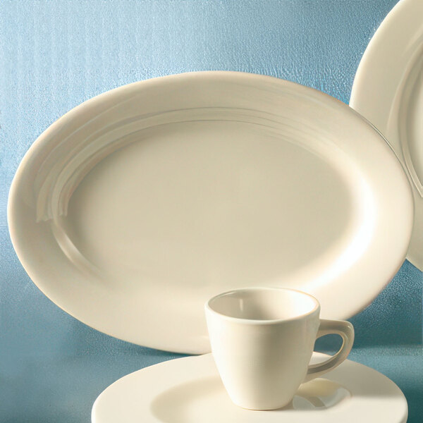 An ivory CAC oval china platter with a white cup and saucer on it.