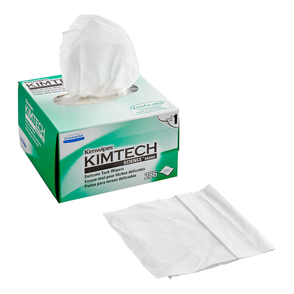 A box of Kimtech Kimwipes 1-ply task wipers with one wiper pulled out and a single wiper sheet displayed beside the box.