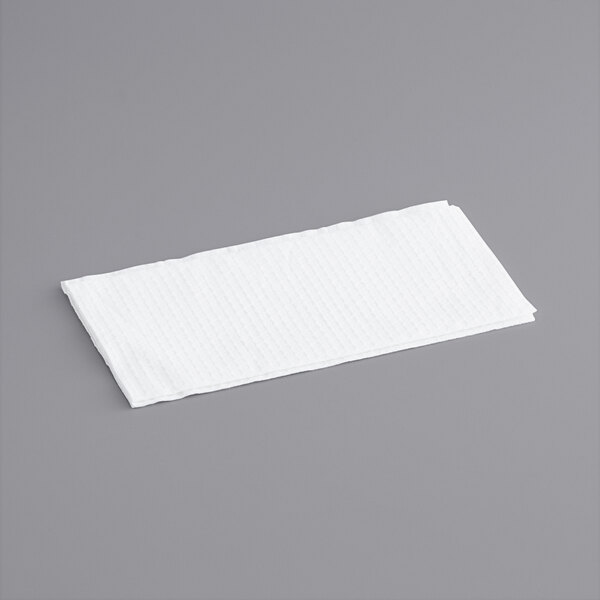 A white WypAll wiper on a gray surface.