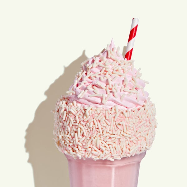 A pink ice cream cone with Adourne white sprinkles.