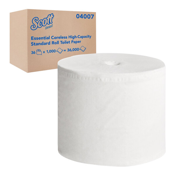 A Scott Essential box with a roll of white toilet paper next to it.