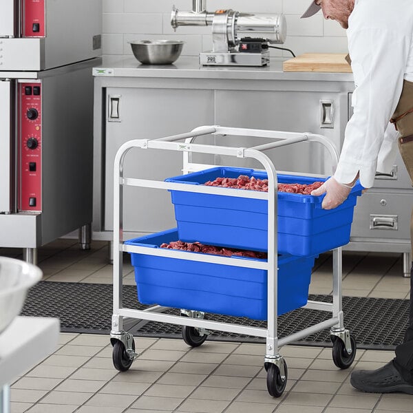 A man in a white shirt holding two blue Regency meat tote boxes.