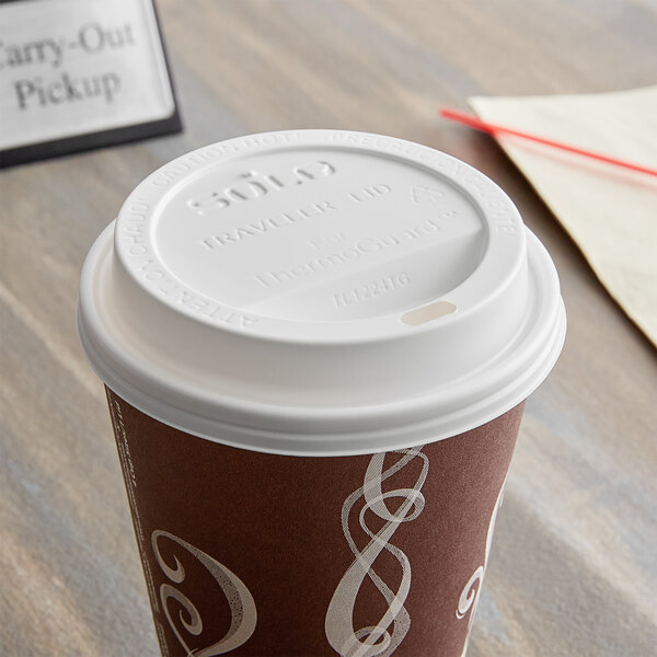 A Dart white paper hot cup lid with a sip hole on a coffee cup.