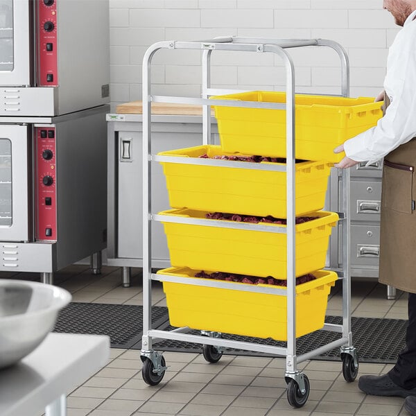 A man in a kitchen assembling a Regency aluminum lug rack with yellow tote boxes on it.