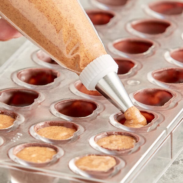 American Almond Naturally Roasted Almond Butter being piped into a tray of chocolates using a pastry bag.