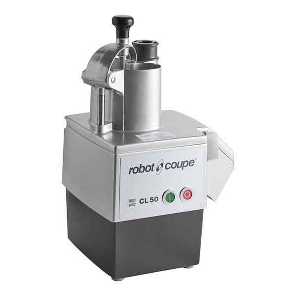 A countertop food processor with a metallic top, cylindrical feed chute, and control buttons on the front panel.