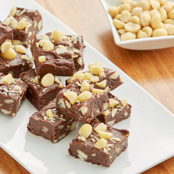 A plate of chocolate fudge with Raw Macadamia Nuts on it.