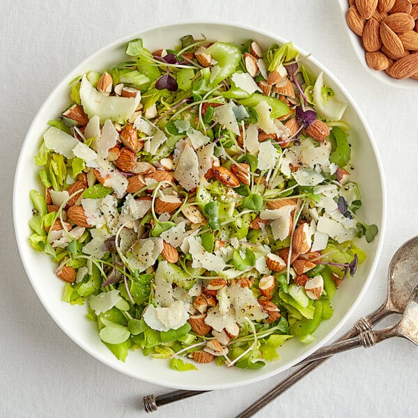 A bowl of salad with almonds, lettuce, and cheese.