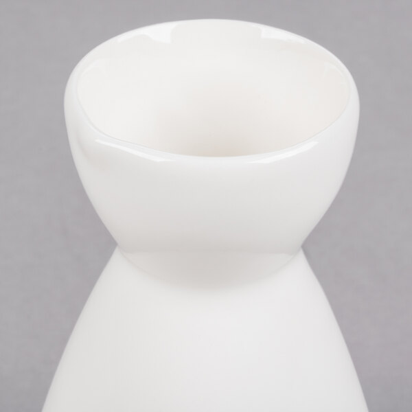A close up of a white porcelain sake bottle with a small opening.