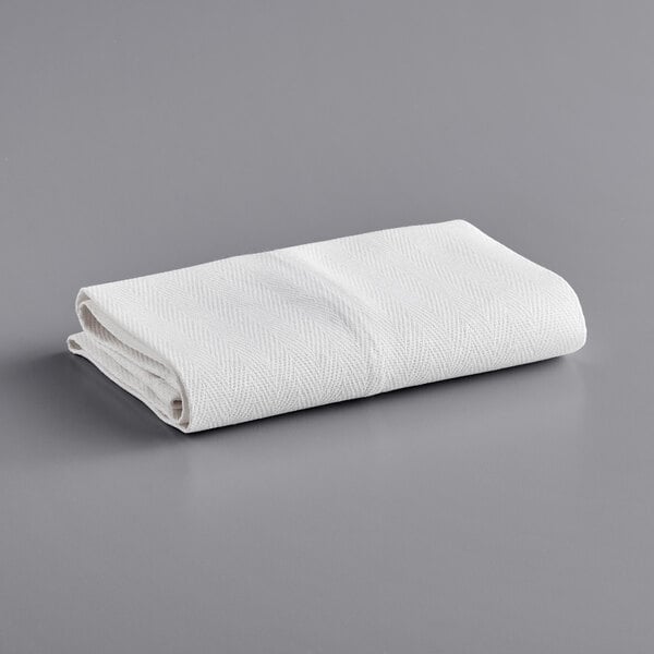 A folded white Choice kitchen towel on a gray surface.