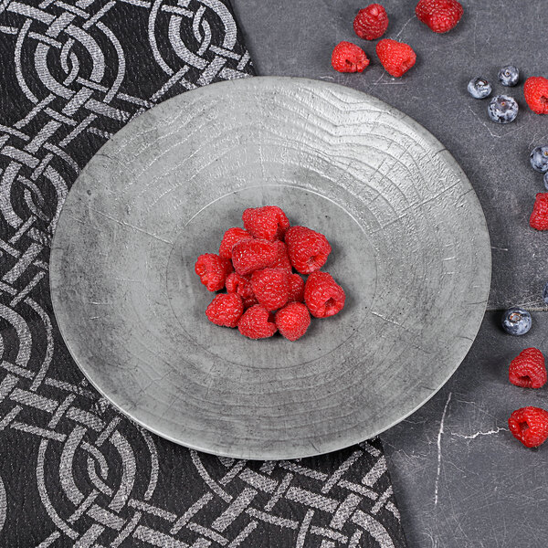 A Denali melamine plate with raspberries and blueberries on it.